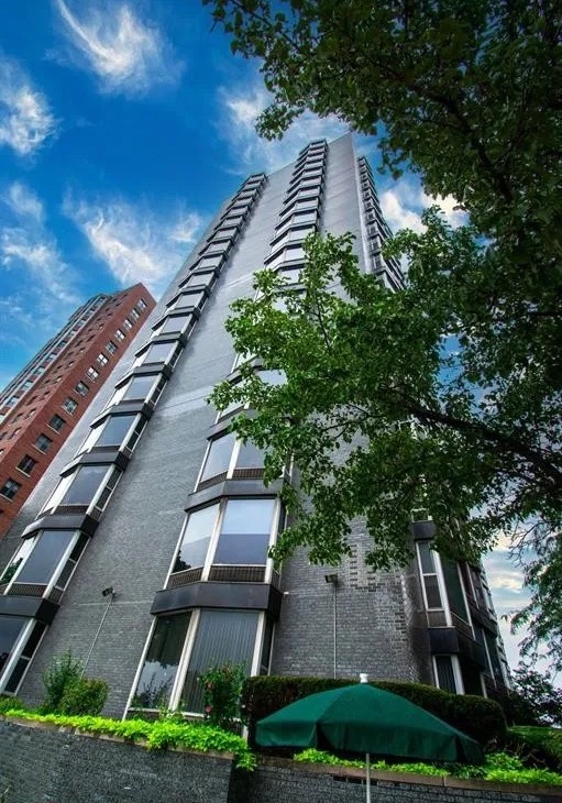 Shoreline East, a tall brick tower with bay windows, seen from below against a blue sky.