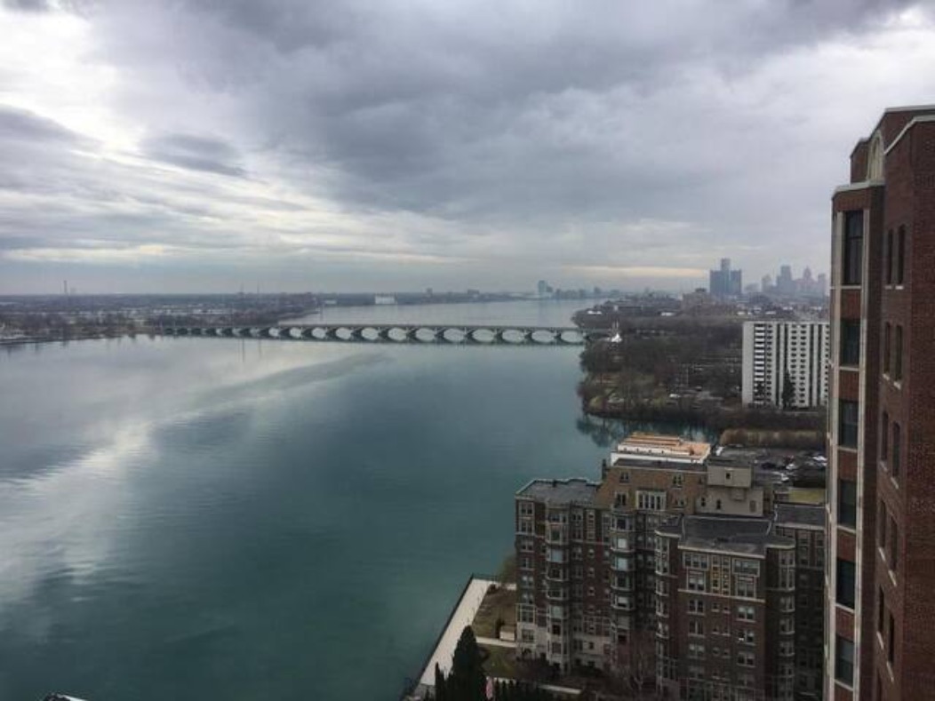 From the Shoreline East roof, looking along the brick face of the building toward downtown Detroit and the river.