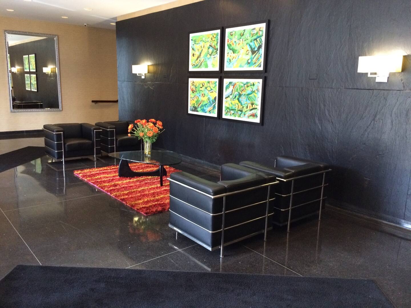 The Shoreline East lobby, with black chairs, a glass table, and a polished stone floor.