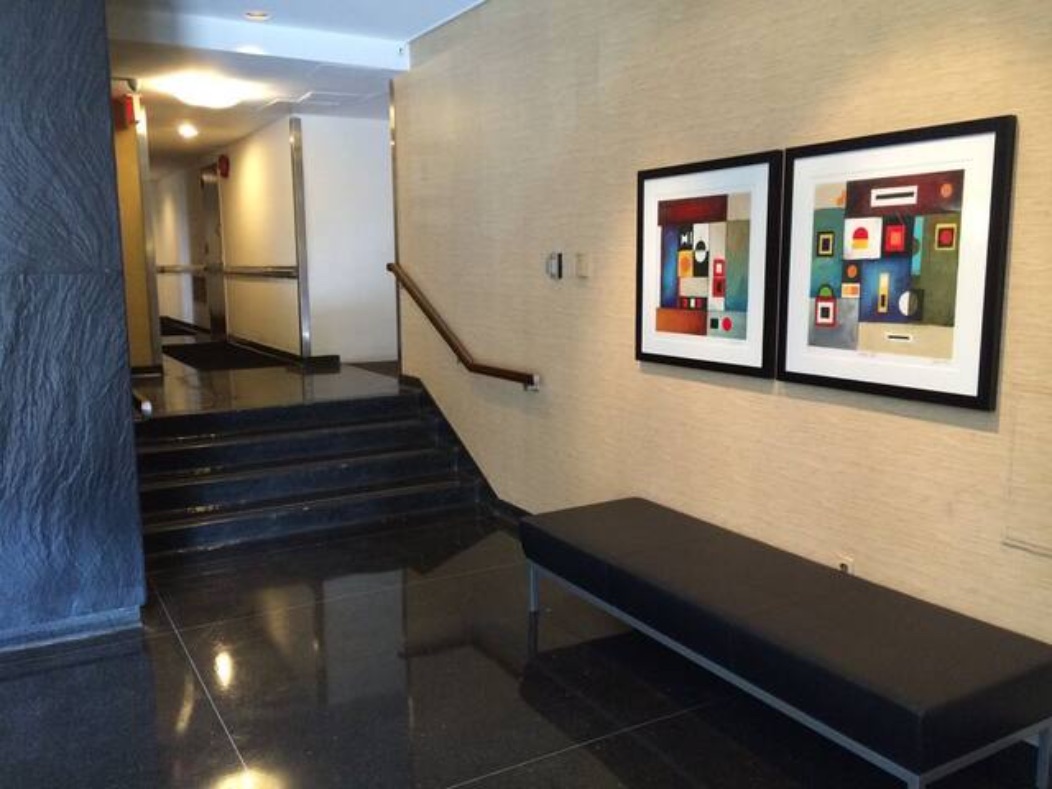 A Shoreline East lobby landing with marble steps, mailboxes, and a bench.