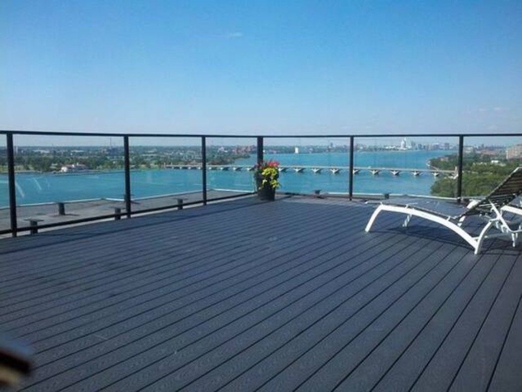 The shared rooftop deck at Shoreline East, with lounge chairs and the Detroit River beyond the railing.